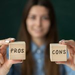 Woman holding Pros and Cons blocks